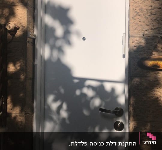 דלת לבנה עם ידית מתכת וצללים